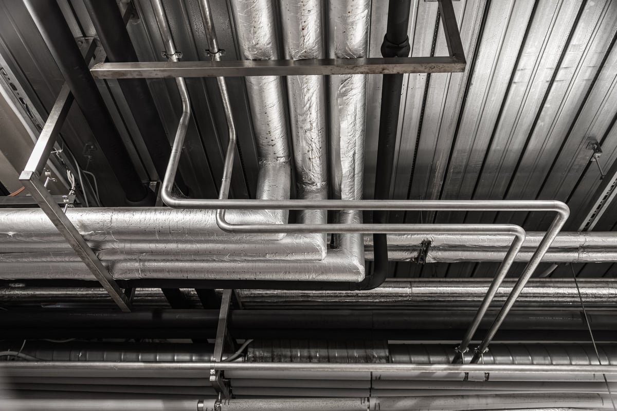 Extractor de aire industrial y ductos metálicos en planta de producción